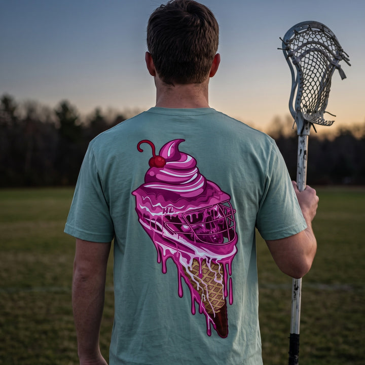Sideline Scoop lacrosse tee in seafoam, back print worn on a lacrosse field at dusk